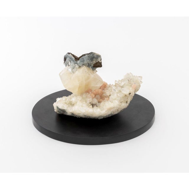 Sky Blue Celestite, Orange Calcite, and Clear Quartz Crystal Cluster Mineral Specimen, on a circular black marble base....