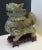 Chinese Hetian Jade carved Foo Dog sensor on a wooden base. Carved base to fit the four-footed stand of the dog. Olive to...