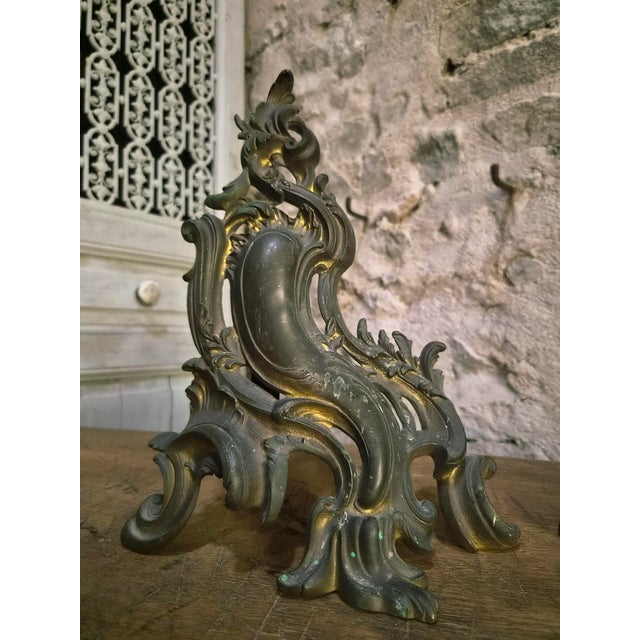 A pair of antique French bronze andirons dating from the late 19th century, made in the Louis XV Revival style. Originally...