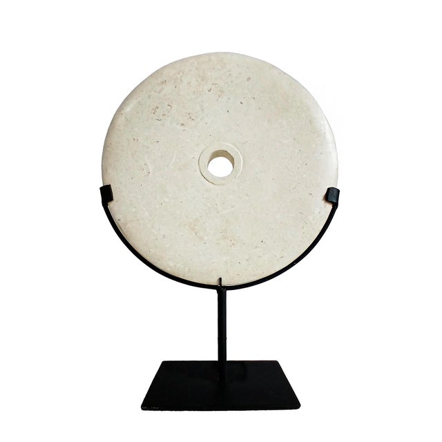 A cream-colored marble disk, hand-carved in Indonesia, contemporary. Reminiscent of the traditional "Bi" disks omnipresent...