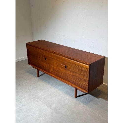Refined mid-century modern sideboard by White & Newton , crafted in beautifully grained teak wood and raised on elegant...