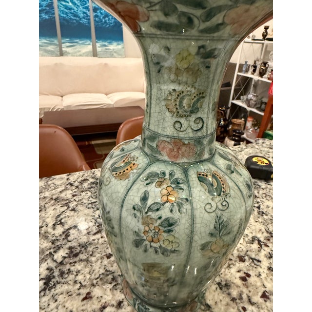 This porcelain vase exemplifies the famille-verte (green family) decorative style that flourished during the Qing Dynasty...