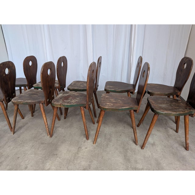 Vintage wooden dining chairs made in Yugoslavia, circa 1960s–1970s. The chairs feature a charming rustic folk design with...