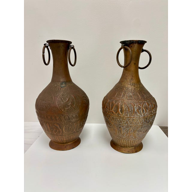 Two charming handmade and decorated vessels with 2 ring handles most likely from the Middle East. The repousse decorations...