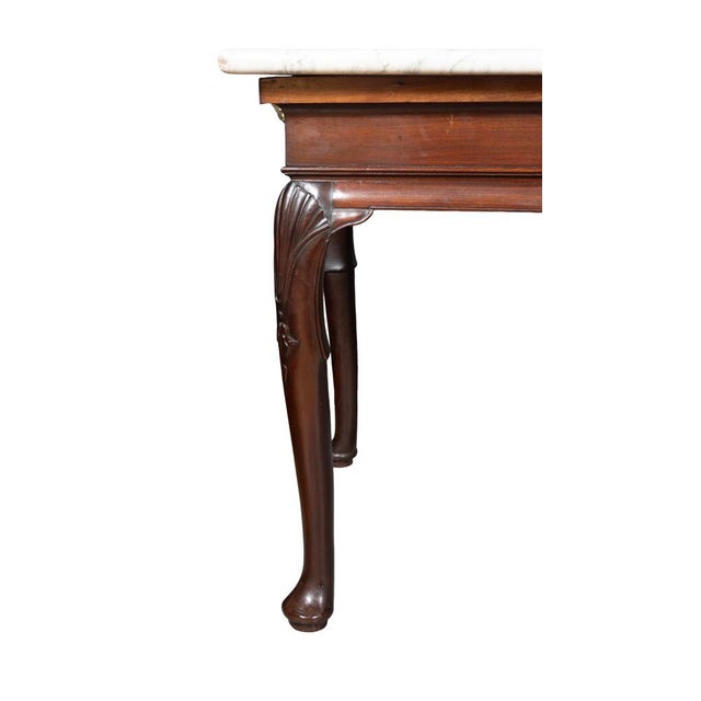 George II mahogany side table, possibly Irish. Rectangular marble top with a conforming frieze raised on cabriole legs...