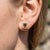 Embrace earthy luxury with these refined halo stud earrings, highlighting an emerald-cut natural gemstone nestled within a...