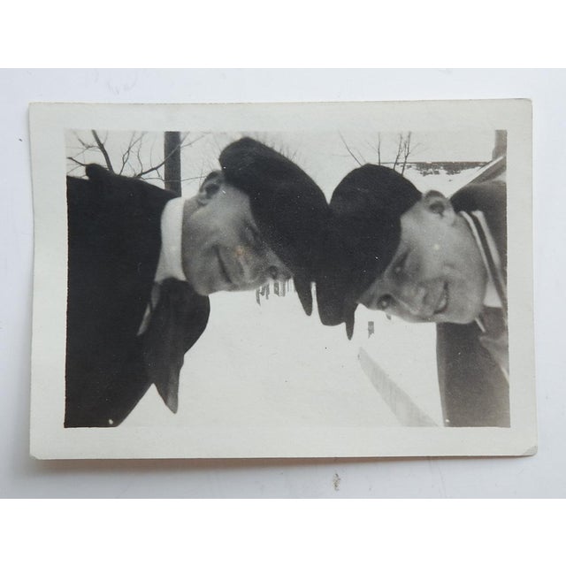 Early 20th century snapshot photograph of a couple guys with caps butting heads on a snowy winter day. Unframed. Id's on...