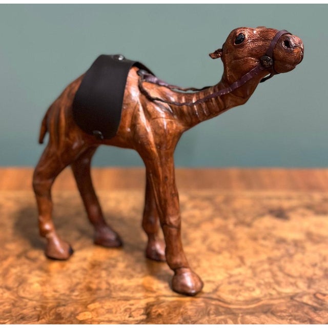 Camel sculpture with lovely aged leather on hand-carved wood. It has been made for Liberty's in London. This lovely camel...