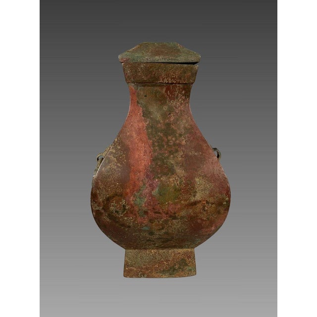 Bronze vase with a red patina, Early Han Dynasty (206 BC - 220 AD). The vase is decorated with Taotie masks ending in...