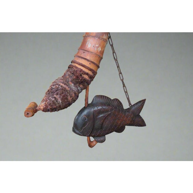 This wonderful antique artifact from Meiji Japan was hand carved from wood to create a stylistic depiction of a swimming...