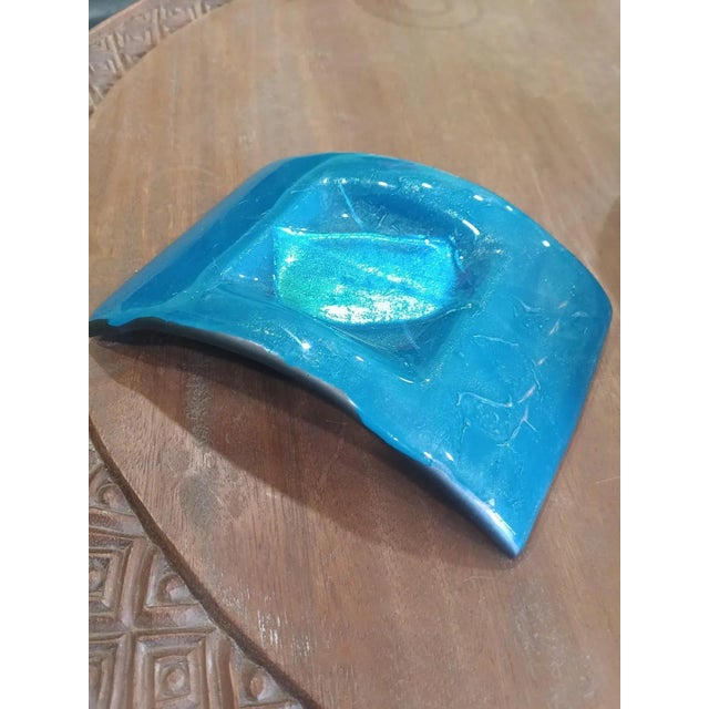 Vibrant mid-century modern fused glass dish with iridescent shimmer. Handcrafted in vivid aqua blue with a striking...