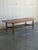 This rectangular teak coffee table combines a long narrow top with a full-length slatted lower shelf. Rounded corners and...
