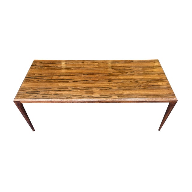 Made in the 1960s, this rosewood coffee table was designed by Johannes Andersen for CFC Silkeborg. It has a smooth...