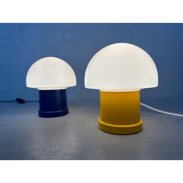 Small ‘mushroom’ table lamp by Massive. The lamp has a yellow or blue plastic base and a white plastic shade. E14 fitting....