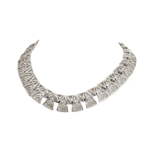 This is part of Chairish’s Costume Jewelry assortment. 1960s modernist rhodium plated interlocking V shapes collar...