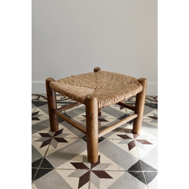 Low stool with a wooden frame and a beautiful herringbone-woven straw seat. Its simple shape and thick legs give it an...