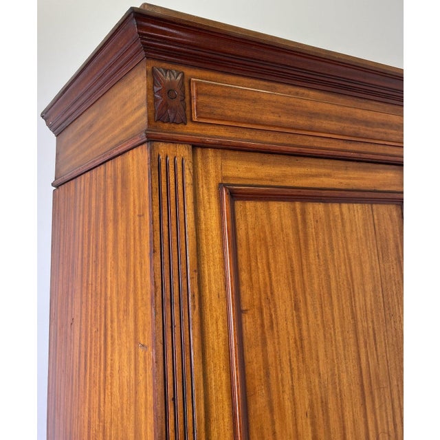This elegant Antique French wardrobe showcases a classic mahogany finish with clean lines, panelled doors, and attractive...