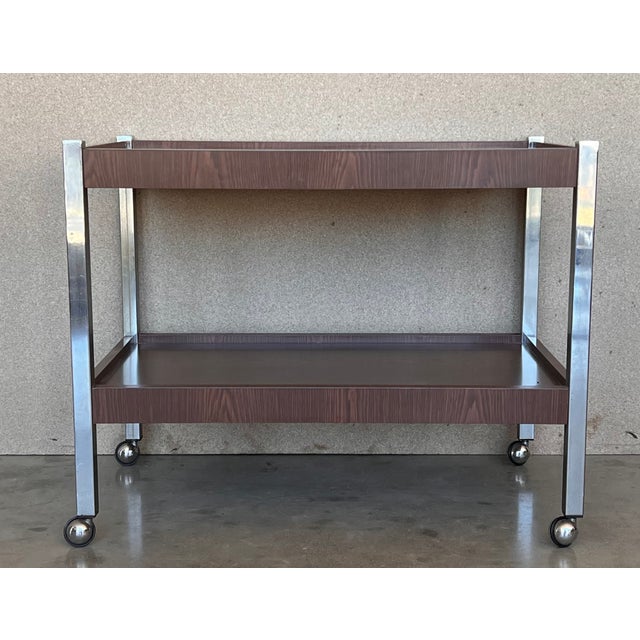 Cubist Industrial solid chromed metal frame with inset white Formica wengé shelves. In original good condition. The wheels...