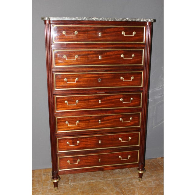 A Louis XVI period mahogany and mahogany veneer chest of drawers, opening with six drawers, including one double drawer,...
