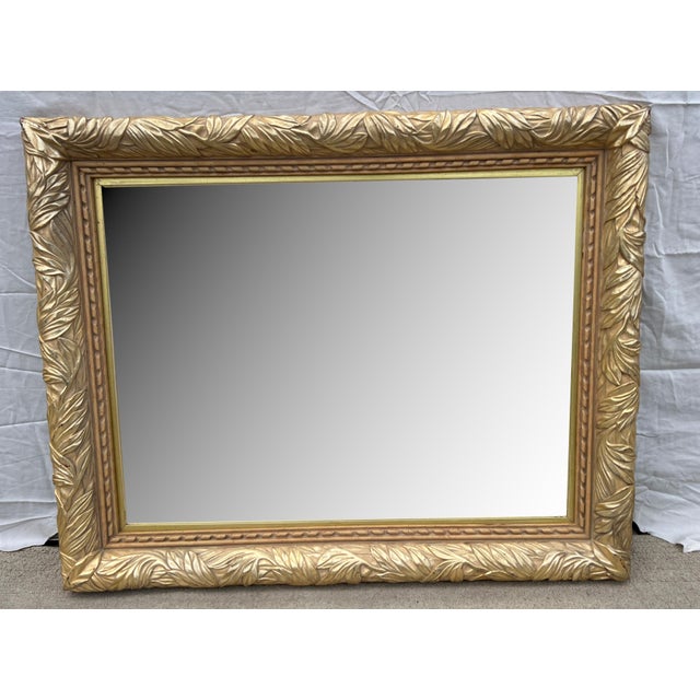 Stunning vintage light gold wall mirror in a Hollywood Regency Neo-Classical style, crafted in the early 1980s. This piece...