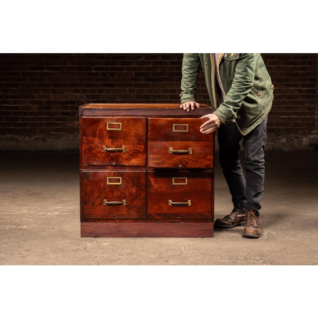 Two-tier oak filing cabinet with four equal drawers, each fitted with brass label holders and pulls. The case presents a...