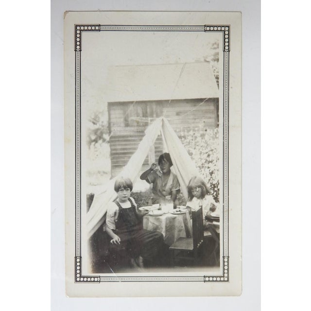 Early 20th century snapshot photograph of children playing fancy tea party. Unframed.