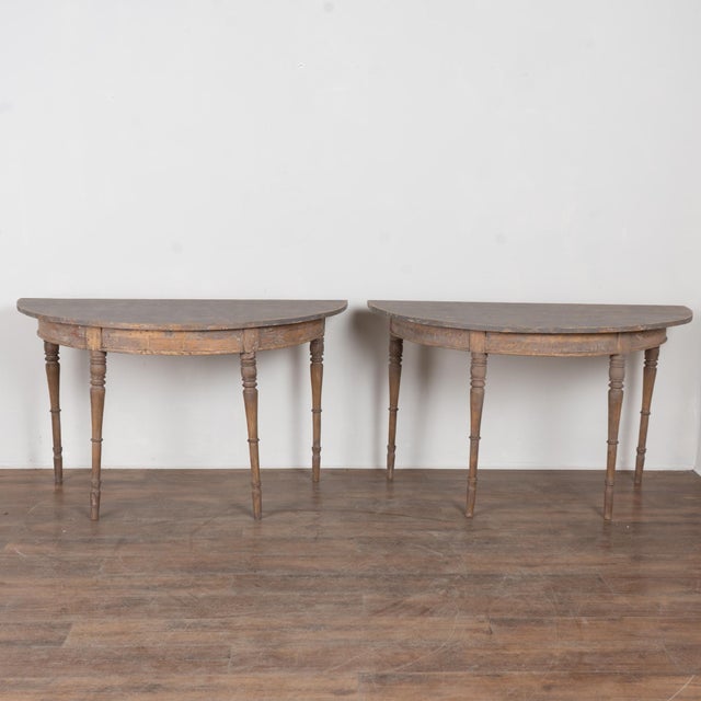 19th-century pair of Swedish pine demilune console tables with turned legs and a generously scaled form. The tables retain...