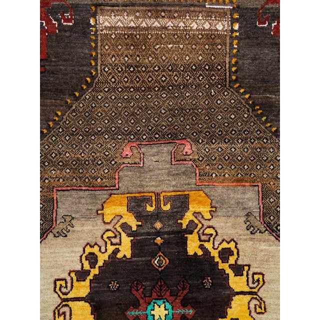 A vintage Turkish Anatolian rug handmade during the mid-20th century with a field in several shades of light and dark...