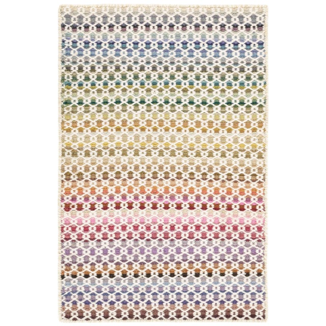 An aesthetic and unique use of pattern and color in a free-spirited, wool woven rug. An ivory linked-lattice is...