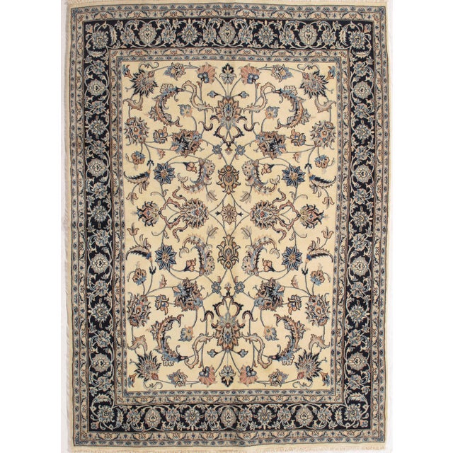 Antique hand-knotted Persian Mashad wool rug with an ivory field featuring a symmetrical allover floral pattern of...