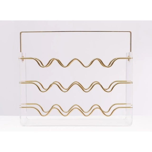 Very nice acrylic glass and brass wine rack. Hollywood Regency style. Fits 12 bottles. Good condition. Good quality piece....