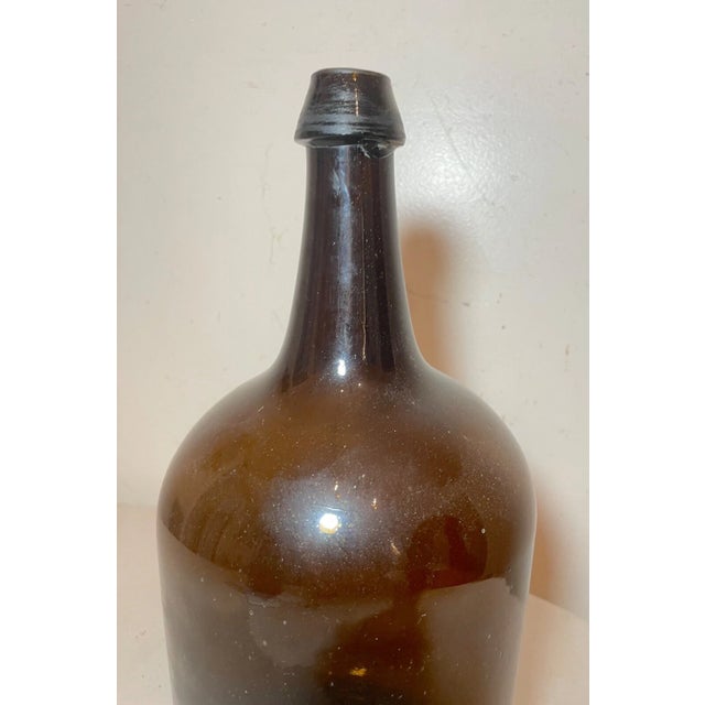 Up for sale is a large antique 19th century hand blown glass demijohn wine bottle. It's blown by hand out of thick green...