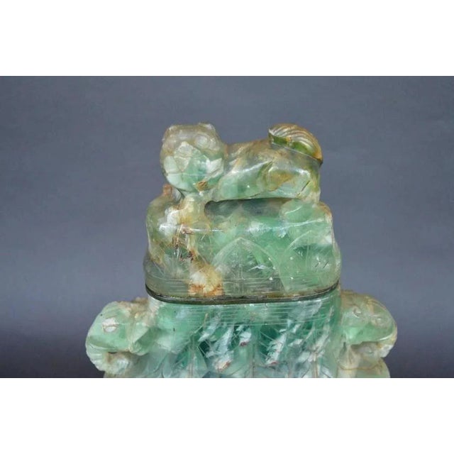 Chinese green hand-carved fluorite vase with a wood base. Made in the early 20th Century, c. 1910. Dimensions: 18.5"H x...