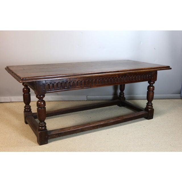 Large oak dining table resting on four baluster legs joined by a stretcher. The frieze is carved with ogival motifs. Very...