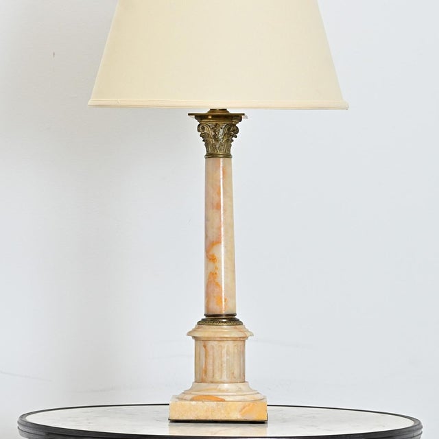 A French Neoclassical table lamp from the 19th century, carved from onyx as a column adorned with cast brass fittings at...
