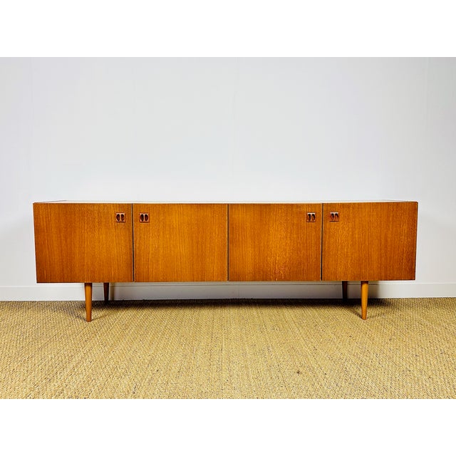 Vintage Scandinavian teak sideboard dating from the 1960s, featuring four storage doors with minimalist shelves. Convex...