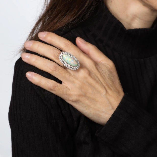 Stylish natural opal & diamond elongated cocktail ring (circa 1960s) crafted in 14k white gold. Natural opal measures 23mm...