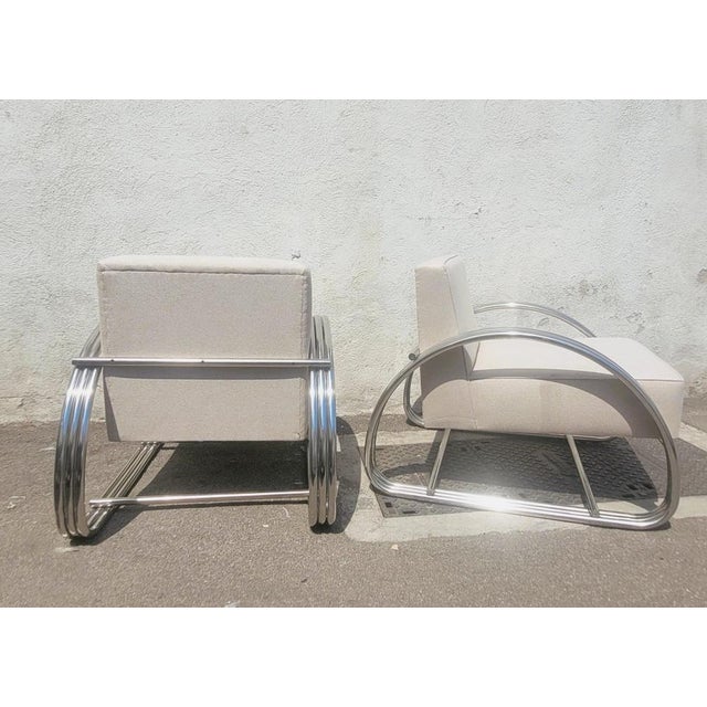 Pair of large chrome armchairs with rounded tubing, in the Art Deco style; based on the Hudson model by designer Ralph...