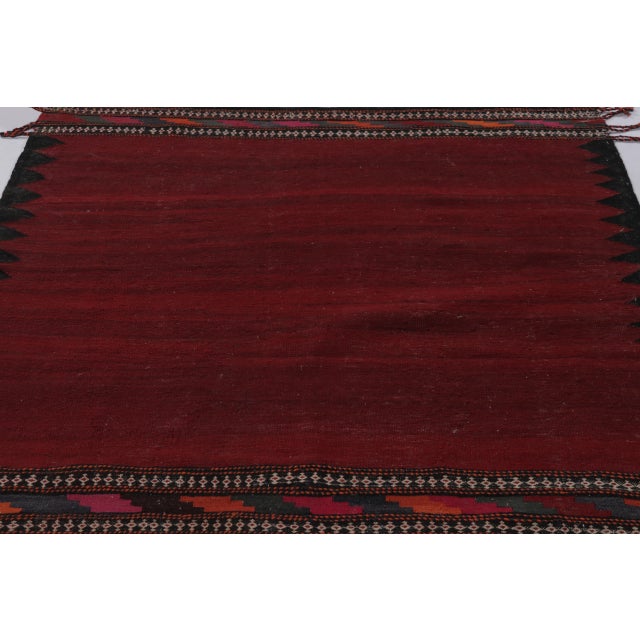 This vintage Afghan kilim rug, measuring 6 x 5, represents a striking example of mid-century tribal flatweave...