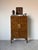 Beautiful Mid Century Hollywood Regency cabinet featuring a striking faux tortoiseshell finish, sculptural brass hardware....
