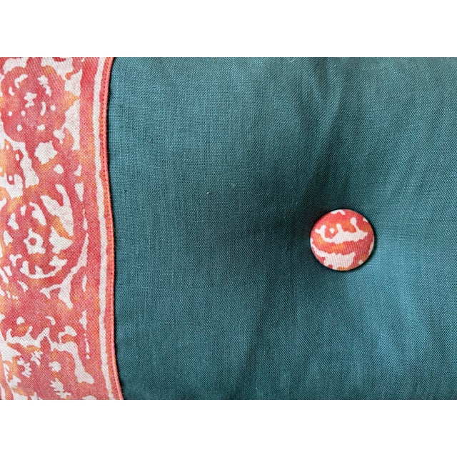 A pillow made from an iconic Fortuny printed fabric border motif, button tuft detail.