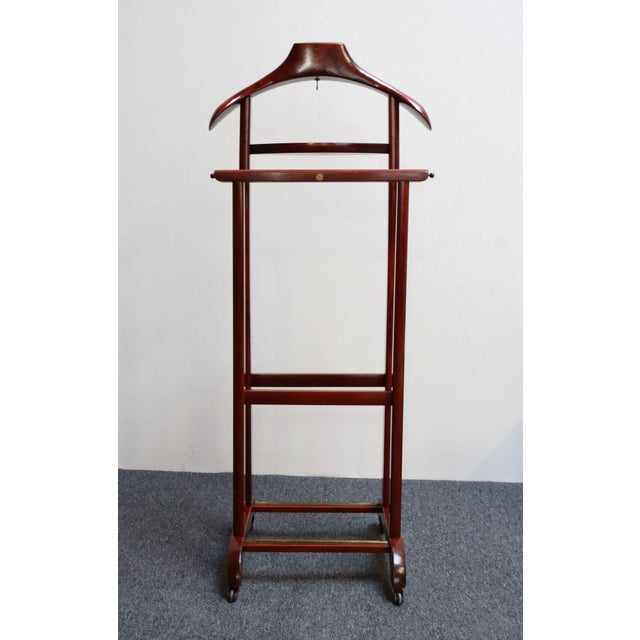 Handsome Italian valet in red mahogany designed by Fratelli Reguitti in the 1950s. Unique example with two-segment...