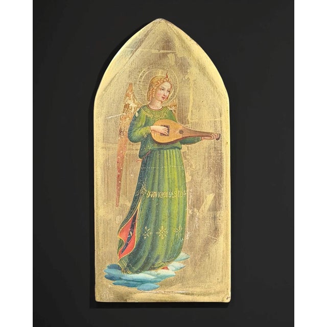 This refined antique devotional panel depicts a serene angel musician, delicately playing a string instrument while...