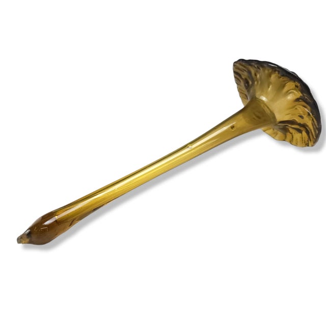 This is a stunning amber glass trumpet flower figurine. The item features a blown glass flower figurine in the shape of a...