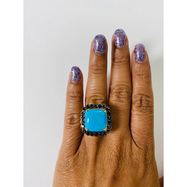 A unique stunner! This ring has a large 9.45 Carat Cushion Cut Turquoise and is surrounded by 22 Pave Set Black Round Cut...
