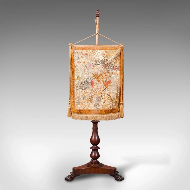 This is an antique pendant pole screen. An English, mahogany and silk cotton fireside tapestry stand, dating to the...