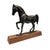 A striking vintage cast metal horse sculpture mounted on a solid wood plinth, depicting a graceful horse in a poised,...