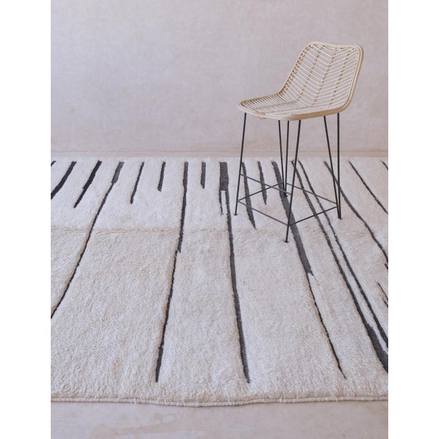 Add a touch of modern elegance to your home decor with our Moroccan Beni MRirt Wool Rug. Measuring 10.8 x 7.6 ft, this...