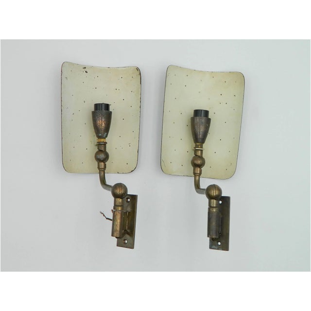 This pair of wall lights was produced by Nikoll Vienna in the 1950s. It consists of a solid brass wall mount that is...