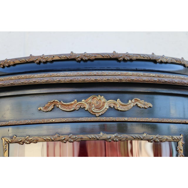 Beautiful French Louis XV-style vitrine display cabinet dating to circa 1940s, featuring an elegant curved silhouette,...